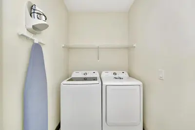 a small laundry room with a washer and dryer at Peachy Dream Cottage With Private Pool Near Disney And Margaritaville Resort &Land H2O Access - 8016Kd in Orlando