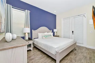 a bedroom with a white bed and a blue wall at Inviting Cottage With Private Pool Near Disney With Margaritaville Resort & Island H2O Access - 8022Kd in Orlando