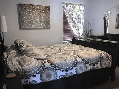 a bedroom with a bed with a comforter and a window at Sunny South Facing Pool with Hot Tub and Lake View Near Disney in Kissimmee