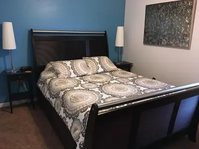 a bed in a bedroom with two night stands and two lamps at Sunny South Facing Pool with Hot Tub and Lake View Near Disney in Kissimmee