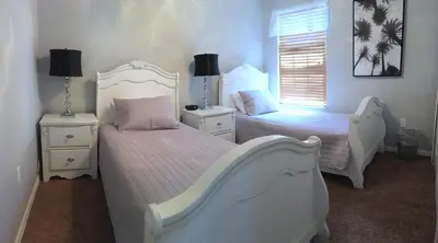 a bedroom with two beds and two night stands at Sunny South Facing Pool with Hot Tub and Lake View Near Disney in Kissimmee
