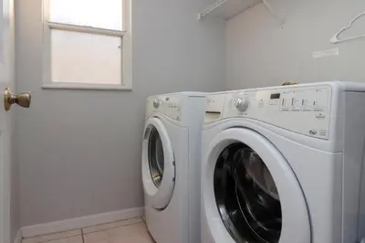 a washing machine in a laundry room with a window at Sunny South Facing Pool with Hot Tub and Lake View Near Disney in Kissimmee