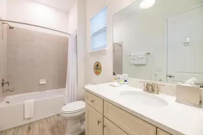 a bathroom with a sink and a toilet and a mirror at Sunset Dream Cottage With Private Pool Near Disney With Margaritaville Resort & Island H2O Access - 8029Kd in Orlando