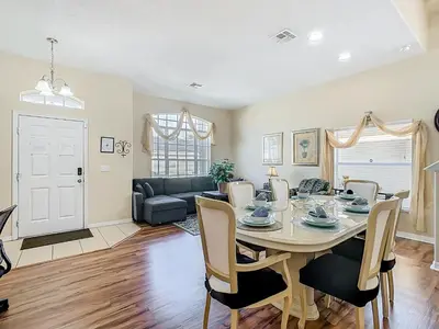a dining room and living room with a table and chairs at Family retreat w pool, spa & BBQ grill in Orlando