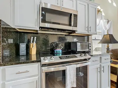 a kitchen with white cabinets and a stove top oven at Family retreat w pool, spa & BBQ grill in Orlando