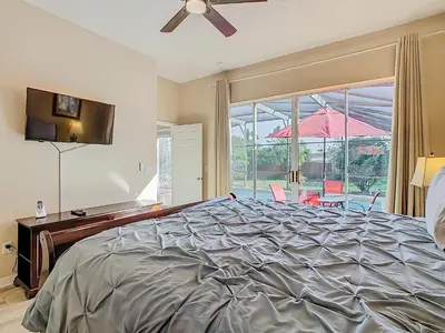 a bedroom with a bed and a window with an umbrella at Family retreat w pool, spa & BBQ grill in Orlando