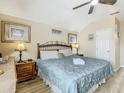 a bedroom with a large bed and a ceiling fan at Family retreat w pool, spa & BBQ grill in Orlando