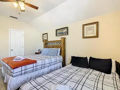 two beds sitting next to each other in a room at Family retreat w pool, spa & BBQ grill in Orlando