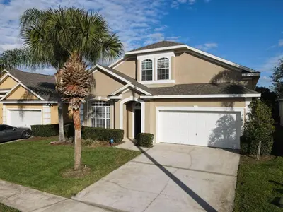 a palm tree in front of a house at Family retreat w pool, spa & BBQ grill in Orlando