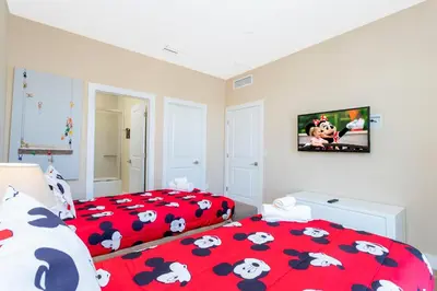 a bedroom with two beds and a tv on the wall at Stunning 4 Bd Close To Disney @ Magic Village 3247 in Orlando