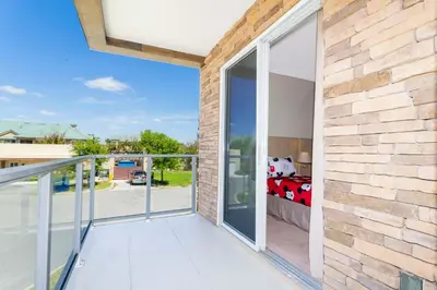 a balcony with sliding glass doors leading to a bedroom at Stunning 4 Bd Close To Disney @ Magic Village 3247 in Orlando