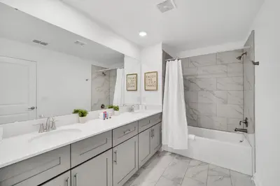 a white bathroom with two sinks and a shower at 4200 Paragraph Drive in Kissimmee
