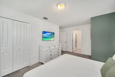 a bedroom with a white bed and a dresser at 4200 Paragraph Drive in Kissimmee