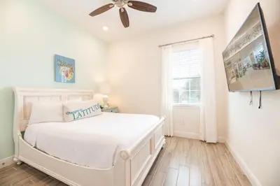 a white bedroom with a bed and a ceiling fan at Vibrant Cottage With Hot Tub Near Disney With Margaritaville Resort & Island H2O Access - 8032Dr in Orlando