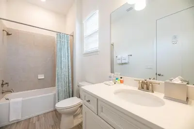 a white bathroom with a sink and a toilet at Vibrant Cottage With Hot Tub Near Disney With Margaritaville Resort & Island H2O Access - 8032Dr in Orlando
