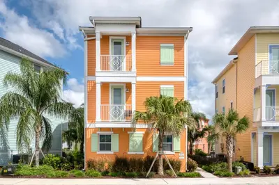 a colorful building with palm trees in front of it at Sunburnt Cottage With Hot Tub Near Disney With Margaritaville Resort & Island H2O Access - 8041Sh in Orlando