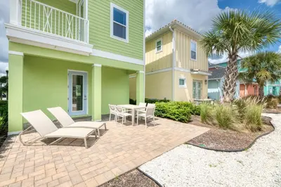a patio with chairs and a table in front of a house at Seaweed Paradise Cottage Near Disney With Margaritaville Resort & Island H2O Access - 8057Kd in Orlando