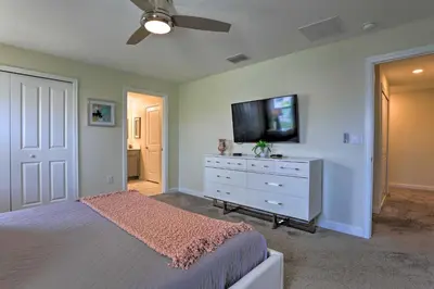 a bedroom with a bed and a flat screen tv at 5 Mi to Disney Chic Townhome with Community Perks! in Kissimmee