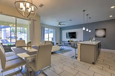 a living room with a kitchen and a dining room at 5 Mi to Disney Chic Townhome with Community Perks! in Kissimmee