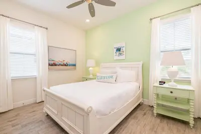 a white bedroom with a bed and a ceiling fan at Sunny Cottage Near Disney With Margaritaville Resort & Island H20 Waterpark Access - 3004Sr in Orlando