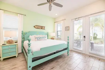 a bedroom with a bed and a ceiling fan at Sunny Cottage Near Disney With Margaritaville Resort & Island H20 Waterpark Access - 3004Sr in Orlando