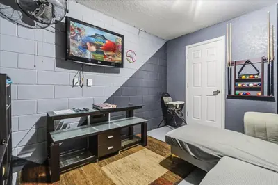 a room with a bed and a tv on a wall at Disney Vacation Oasis Pool BBQ Resort Fun in Orlando