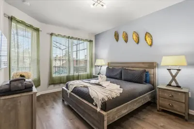 a bedroom with a bed and two windows at Disney Vacation Oasis Pool BBQ Resort Fun in Orlando