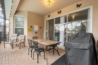 a dining room with a table and chairs and windows at Disney Vacation Oasis Pool BBQ Resort Fun in Orlando