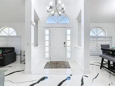 a white living room with a white door and a piano at Casita mi Encanto a Cozy & Spacious House, 4-bedroom 3-Bath & pool in Kissimmee