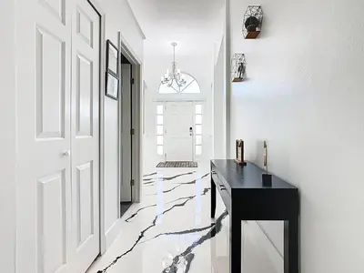 a hallway with a black table and a white wall at Casita mi Encanto a Cozy & Spacious House, 4-bedroom 3-Bath & pool in Kissimmee