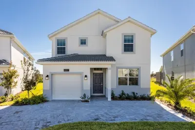 a white house with a garage at 5 bedroom home is ideal for an elegant vacation villa in Kissimmee
