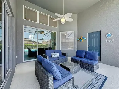 a living room with blue couches and a ceiling fan at Amazing 6 Bed Disney Dream Getaway in Windsor Palm villa in Kissimmee