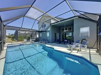 a swimming pool with chairs and a house at Amazing 6 Bed Disney Dream Getaway in Windsor Palm villa in Kissimmee