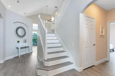 a white staircase in a home with a white door at Amazing 6 Bed Disney Dream Getaway in Windsor Palm villa in Kissimmee