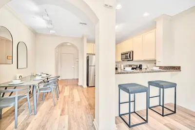 a kitchen and dining room with a table and chairs at Bright 2BR Condo with Pool - near Disney! in Orlando