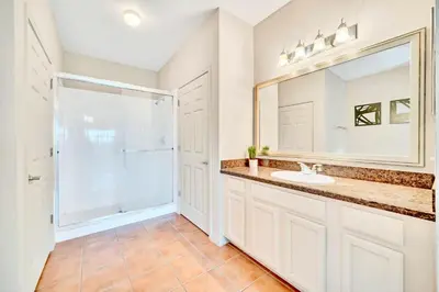 a bathroom with a sink and a mirror at Bright 2BR Condo with Pool - near Disney! in Orlando