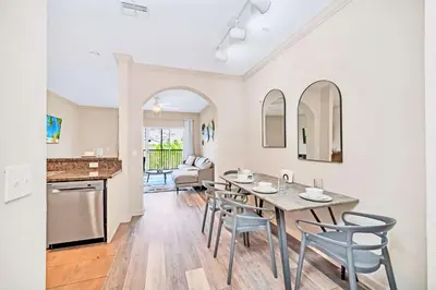 a kitchen and dining room with a table and chairs at Bright 2BR Condo with Pool - near Disney! in Orlando