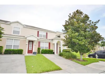 a house with a tree in front of it at 3 Bedroom,3 Bath Townhouse in Gate Resort townhouse in Kissimmee