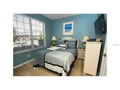 a bedroom with a bed with blue walls and a window at 3 Bedroom,3 Bath Townhouse in Gate Resort townhouse in Kissimmee