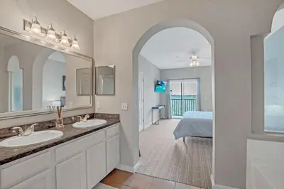 a bathroom with two sinks and a bedroom with a bed at -Relaxing 3BR Near Disney - Pool in Orlando