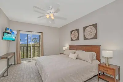 a bedroom with a bed with a ceiling fan and a window at -Relaxing 3BR Near Disney - Pool in Orlando