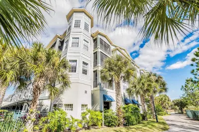 a white building with palm trees in front of it at -Relaxing 3BR Near Disney - Pool in Orlando