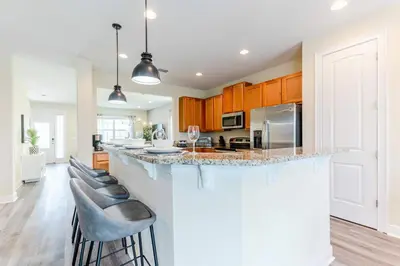 a kitchen with a large island with bar stools at Encore Resort 6 Bedroom Home with Pool 2300 in Orlando