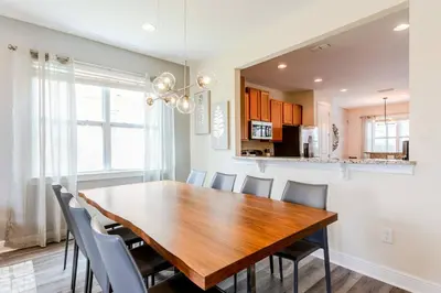 a kitchen and dining room with a wooden table and chairs at Encore Resort 6 Bedroom Home with Pool 2300 in Orlando