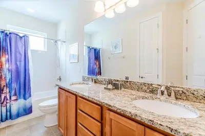 a bathroom with two sinks and a toilet at Encore Resort 6 Bedroom Home with Pool 2300 in Orlando