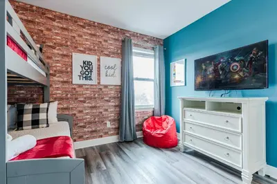 a bedroom with blue walls and a brick wall at Encore Resort 6 Bedroom Home with Pool 2300 in Orlando