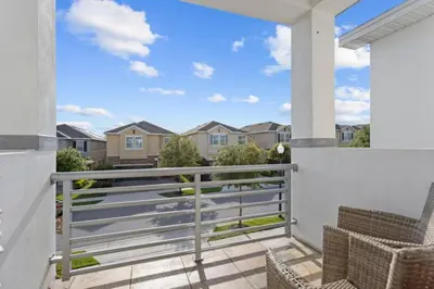 a balcony with chairs and a view of condos at 360 Pendant Ct · 360 Villa - 7BD - Pool Theme Beds by Disney in Orlando