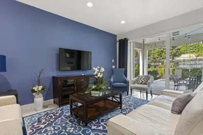 a living room with a white couch and a blue wall at 360 Pendant Ct · 360 Villa - 7BD - Pool Theme Beds by Disney in Orlando