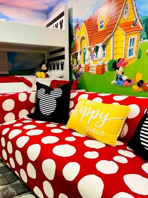 a bedroom with two beds and a mural of a house at Happiest House on Earth near Disney World 9 Bedroom, Pool, Theater, Gameroom, Mickey Bunk room with Twisty Slide in Storey Lake in Kissimmee