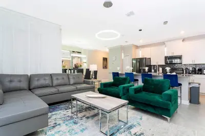 a living room with a couch and chairs and a kitchen at Gorgeous 4 Bd Close to Disney w/ Pool @ Storey Lake Resort 4245 in Kissimmee